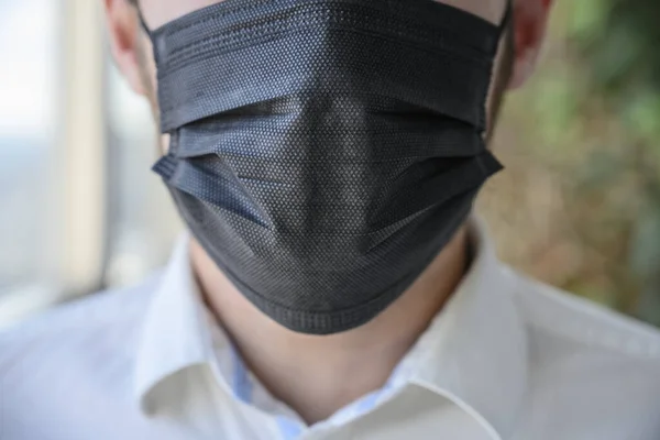 Egy férfi fekete légzőmaszkot visel az arcán. — Stock Fotó