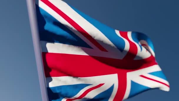 La bandera nacional de Gran Bretaña ondea en el viento contra un cielo azul — Vídeo de stock