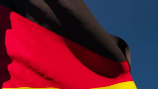 La bandera nacional de Alemania ondea en el viento contra un cielo azul — Vídeo de stock