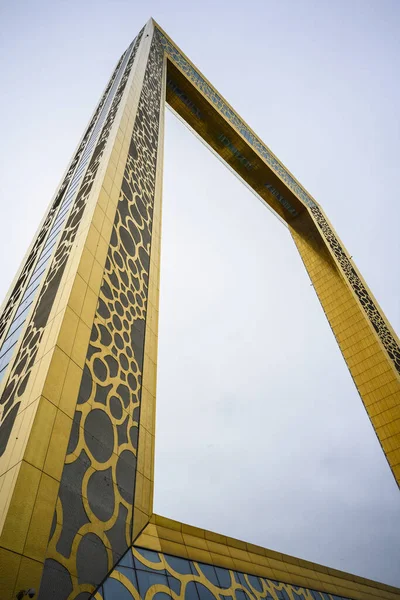 Edificio de gran altura en forma de marco de oro en Dubai, Emiratos Árabes Unidos. Día claro 14 marzo 2020 — Foto de Stock