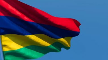 Mauritius 'un ulusal bayrağı mavi gökyüzüne karşı rüzgarda dalgalanıyor.
