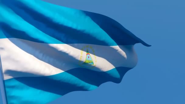 De nationale vlag van Nicaragua wappert in de wind tegen een blauwe lucht — Stockvideo