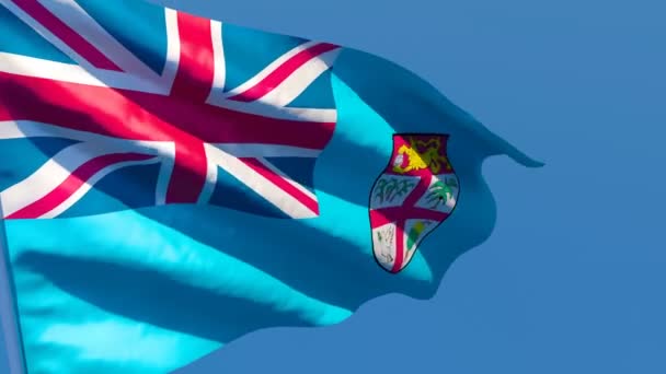 Національний прапор Фіджі пурхає вітром проти блакитного неба. — стокове відео
