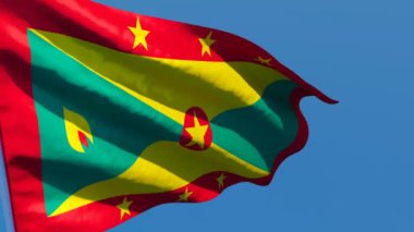 Grenada 'nın ulusal bayrağı mavi gökyüzüne karşı rüzgarda dalgalanıyor.