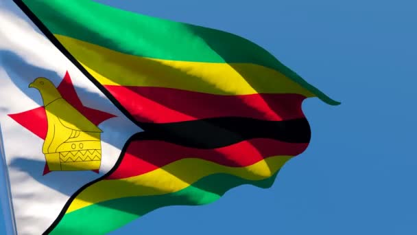 De nationale vlag van Zimbabwe wappert in de wind tegen een blauwe lucht — Stockvideo