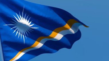 Marshall Adaları 'nın ulusal bayrağı mavi gökyüzüne karşı rüzgarda dalgalanıyor.
