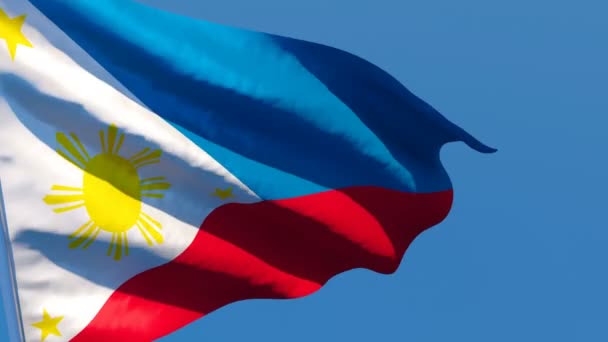 Die philippinische Nationalflagge flattert im Wind vor blauem Himmel — Stockvideo