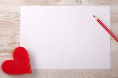 Kırmızı kalp. Sevgililer günü mesajı. Masanın üzerine kalem.