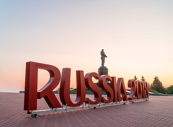 Nizhny Novgorod, Russia - August 23, 2017: Installation of the inscription "Russia 2018" for World Cup at sunrise with a monument to Valery Chkalov against the background.