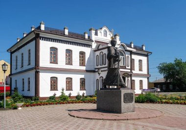 Ishim, Rusya - 16 Temmuz 2018: Praskove Lupolova bronz anıtı Ishim Yerel Lore Müzesi 'nin arka planında.