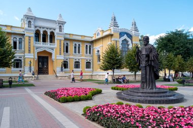 Kislovodsk, Rusya - 8 Eylül 2017: Narzan hamamlarının 19. yüzyıl binası ve Kurortny Bulvarı 'ndaki Harikalar Diyarı Aziz Nicholas anıtı.
