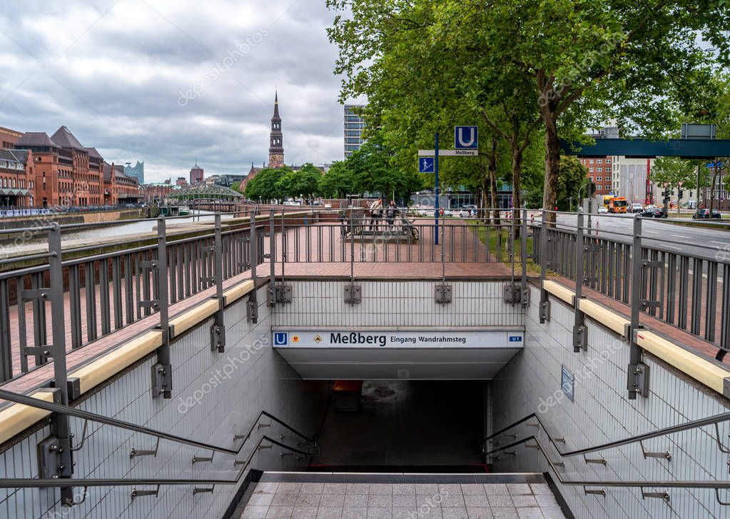 Hamburg, Germany- June 27, 2019: Entrance to the underground station Messberg with cityscape view of Altstadt district.