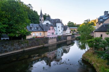 Ev manzarası ve kilise kulesi sabahın erken saatlerinde Alzette nehrine yansıyor. Lüksemburg 'un eski sokakları.