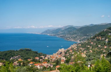 Ligurya Denizi kıyısındaki Camogli şehrinin güzel panoramik manzarası. Geleneksel İtalyan evleri kıyı şeridi boyunca uzanıyor.