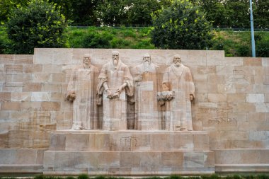 Geneva, Switzerland- July 13, 2019: The International Monument to the Reformation. The centre of the Reformation Wall with four statues of William Farel, John Calvin, Theodore Beza and  John Knox. clipart