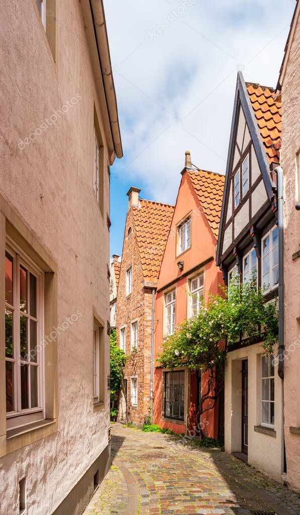 Bremen, Germany. Narrow street of the old town in the historic Schnoor district. Small medieval houses lit by the sun on a summer day.
