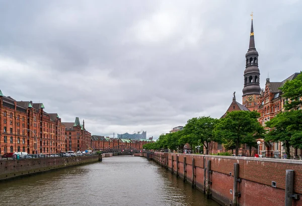 Hamburg, Almanya - 27 Haziran 2019: St. Katharinen Kilisesi kulesi ve Elbphilharmonie Hamburg ile kentin liman kısmına bakan su kanalı.