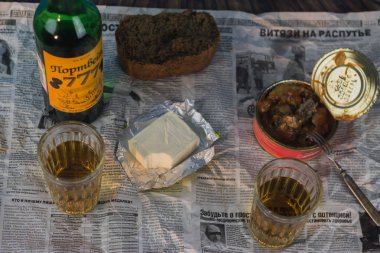 Masada peynir, korunmuş balık ve siyah ekmek içeren bir şişe şarap