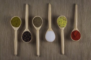 Aroma baharat ışık arka plan üzerinde farklı tipleri ile altı kaşık. Burada bulabilirsiniz: tuz, toz biber, Mısır, kırmızı biber ve iki tür karışık baharat biber