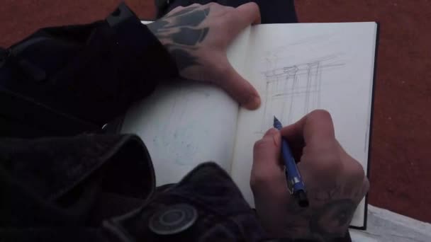 Männliche Hände Tätowierungen Zeichnen Einem Skizzenbuch — Stockvideo