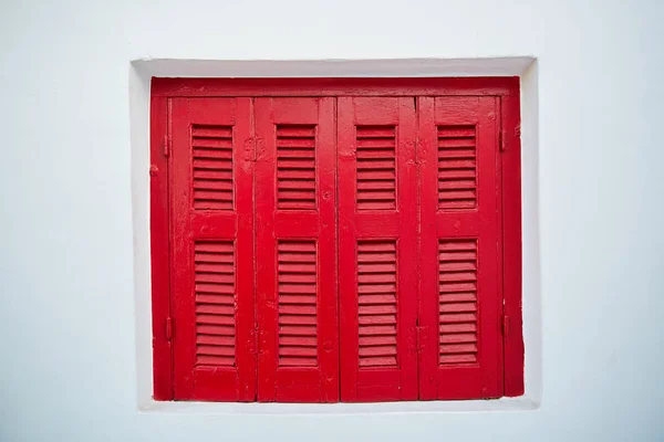 Red wooden window at white wall