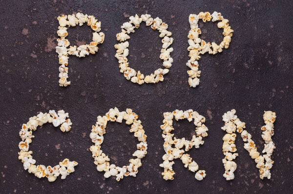 Popcorn lettering (inscription) isolated on brown stone backgrou