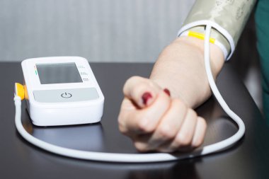 Kadın kendini tonometer ile kan basıncı ölçme