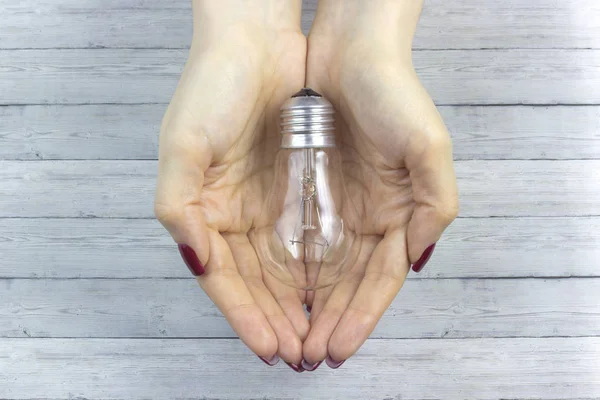 Lampadina in mano donna, immagine realistica della foto. Accendere lampadina tungsteno con la mano — Foto Stock