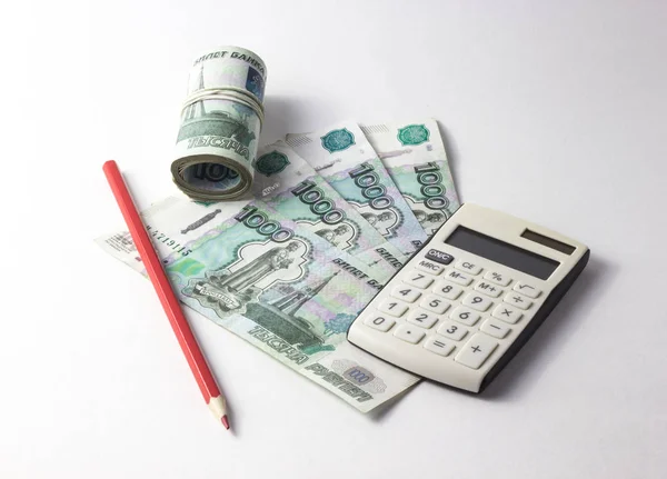 Dinero con una calculadora sobre un fondo blanco — Foto de Stock