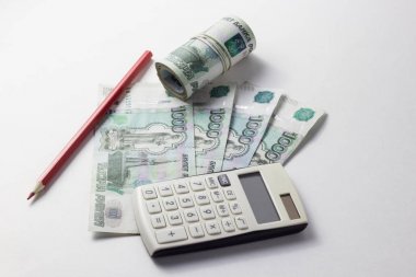Hesap makinesi ve bir sürü para beyaz bir arka plan üzerinde