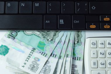 Hesap makinesi ve bir sürü para beyaz bir arka plan üzerinde