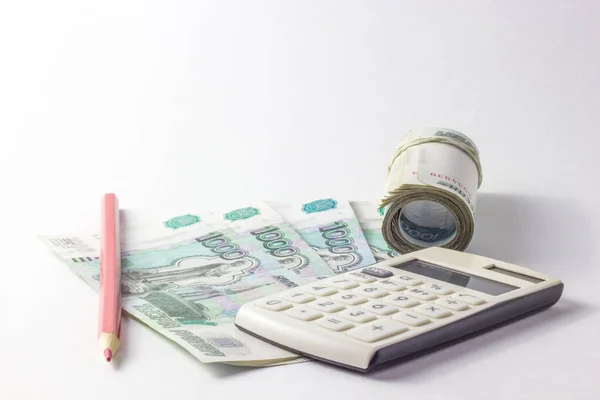 Calculadora y mucho dinero en un fondo blanco — Foto de Stock