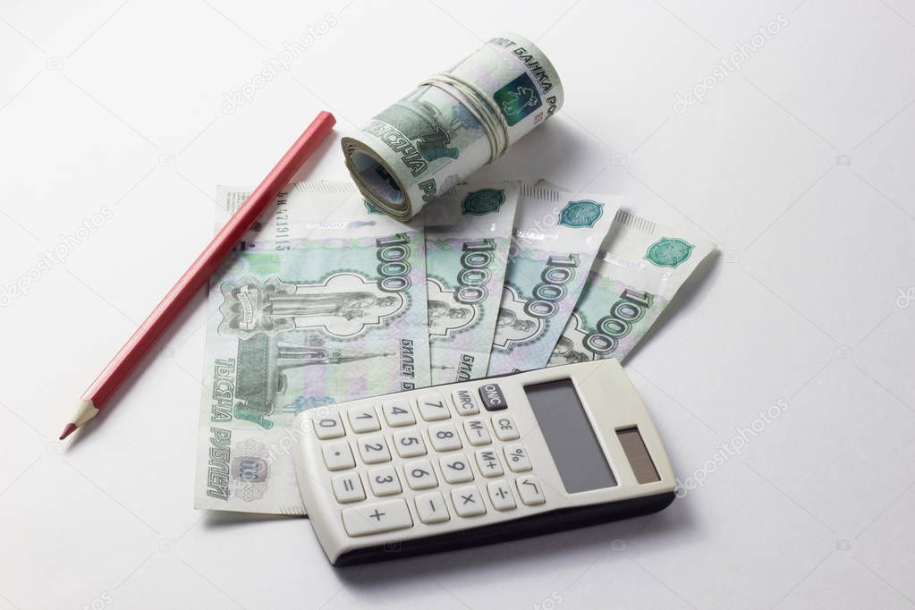 Calculator and a lot of money on a white background