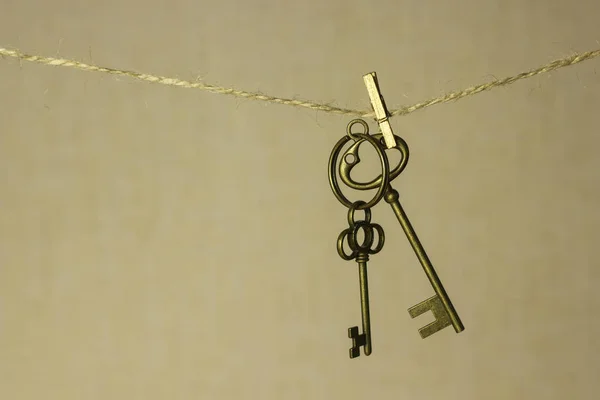 Vintage kulcs lógott egy kötélen egy arany háttér — Stock Fotó