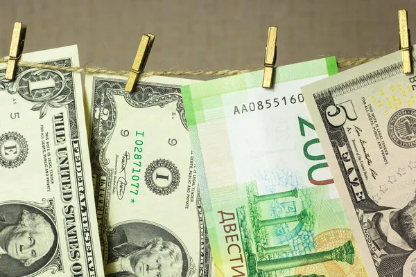 Dólares están colgando en el tendedero pinzas de ropa unidas en un fondo de oro — Foto de Stock