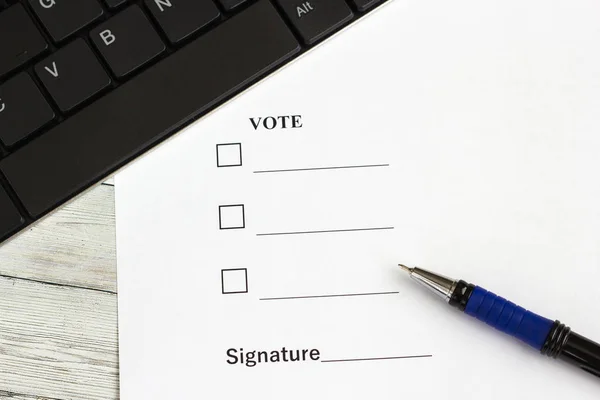 Stylo pour écrire sur une table en bois avec un document pour voter et clavier — Photo