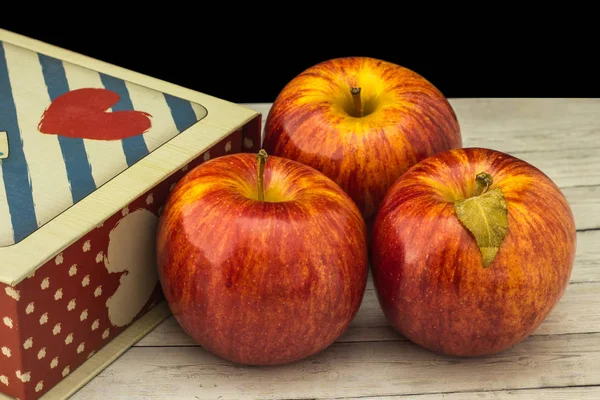 Fruits of a red apple with leaves near the gift box — Stock Photo, Image