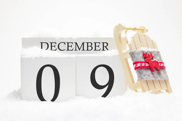 Деревянный календарь на 9 декабря зимнего месяца. Символы зимы - снег и сани. Концепция праздников, каникул и зимних развлечений . — стоковое фото