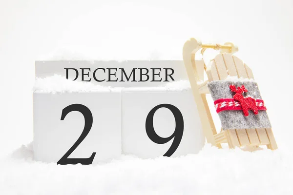 Calendario de madera para el 29 de diciembre, día 29 del mes de invierno. Los símbolos del invierno son la nieve y el trineo. Concepto de vacaciones, vacaciones y diversión invernal . — Foto de Stock