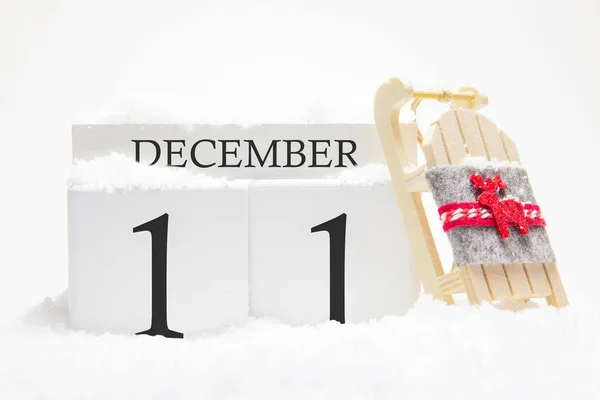 Calendario de madera para el 11 de diciembre del mes de invierno. Los símbolos del invierno son la nieve y el trineo. Concepto de vacaciones, vacaciones y diversión invernal . — Foto de Stock