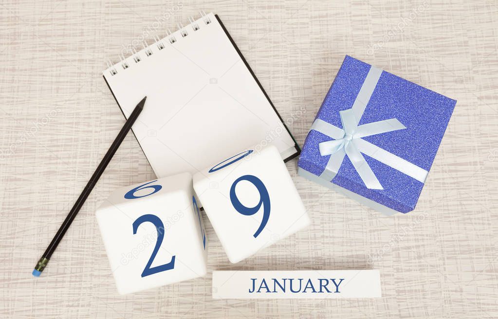 Calendar with trendy blue text and numbers for January 29 and a gift in a box.