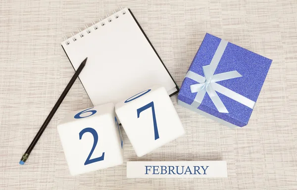 Calendario con texto azul de moda y números para el 27 de febrero y un regalo en una caja . — Foto de Stock