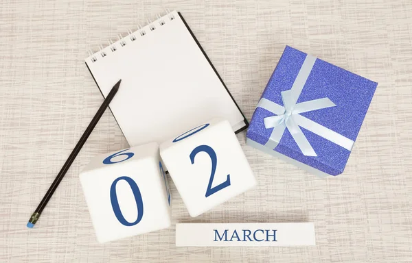 Calendar with trendy blue text and numbers for March 2 and a gift in a box. — Stock Photo, Image