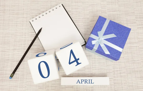 Calendário com texto azul na moda e números para 4 de abril e um presente em uma caixa . — Fotografia de Stock