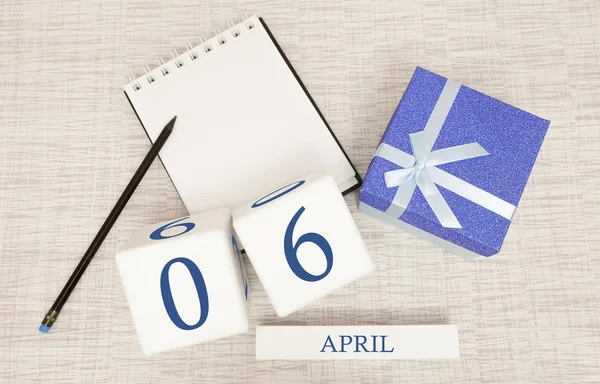 Calendar with trendy blue text and numbers for April 6 and a gift in a box. — Stock Photo, Image