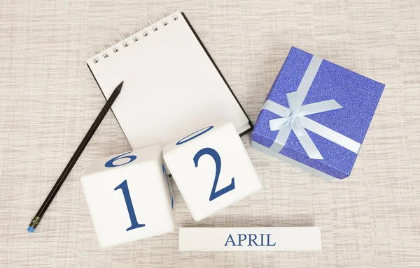 Calendar with trendy blue text and numbers for April 12 and a gift in a box. — Stock Photo, Image