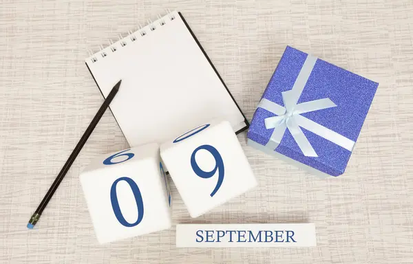 Gift box and wooden calendar with trendy blue numbers, September 9, business planner — Stock Photo, Image