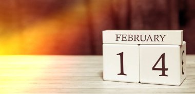 Takvim hatırlatma olayı konsepti. Tahta küplerde sayılar ve 14 Şubat 'ta güneş ışığı..