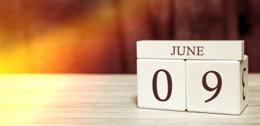 Takvim hatırlatma olayı konsepti. Tahta küplerde sayılar ve 9 Haziran 'da güneş ışığı..