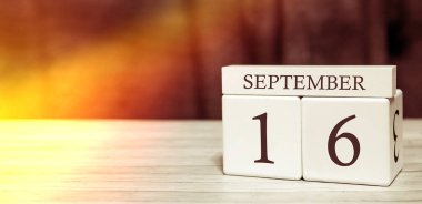 Takvim hatırlatma olayı konsepti. Tahta küplerin sayıları ve ayın 16 'sında güneş ışığı..